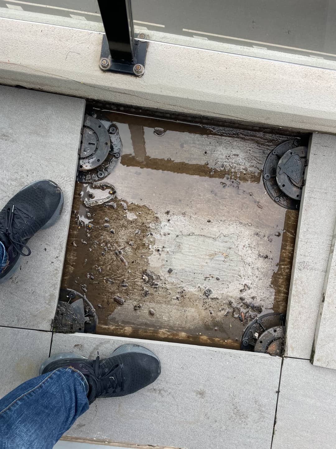 A leaking apartment balcony stripped back to expose the failed waterproofing membrane beneath the tiles