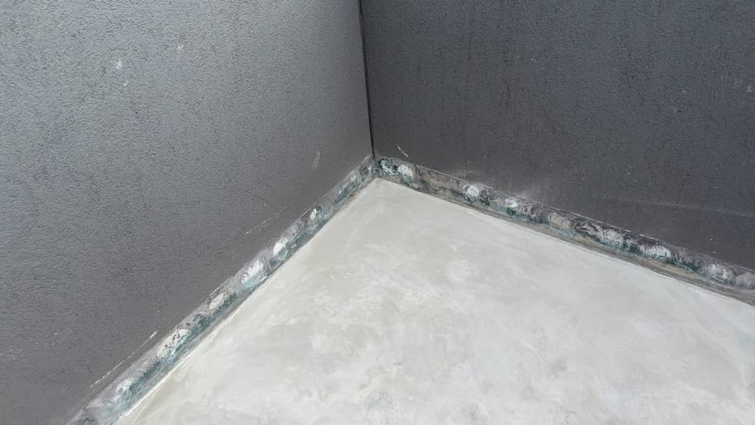 Tiles and screed removed from a balcony to expose the substrate before a new waterproofing membrane is installed