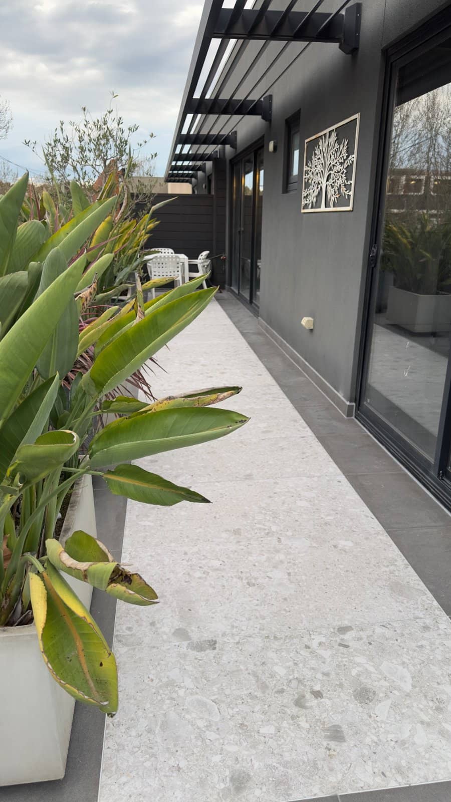 Finished balcony terrace with two tile types used as a feature after a partial waterproofing repair, planter boxes alongside