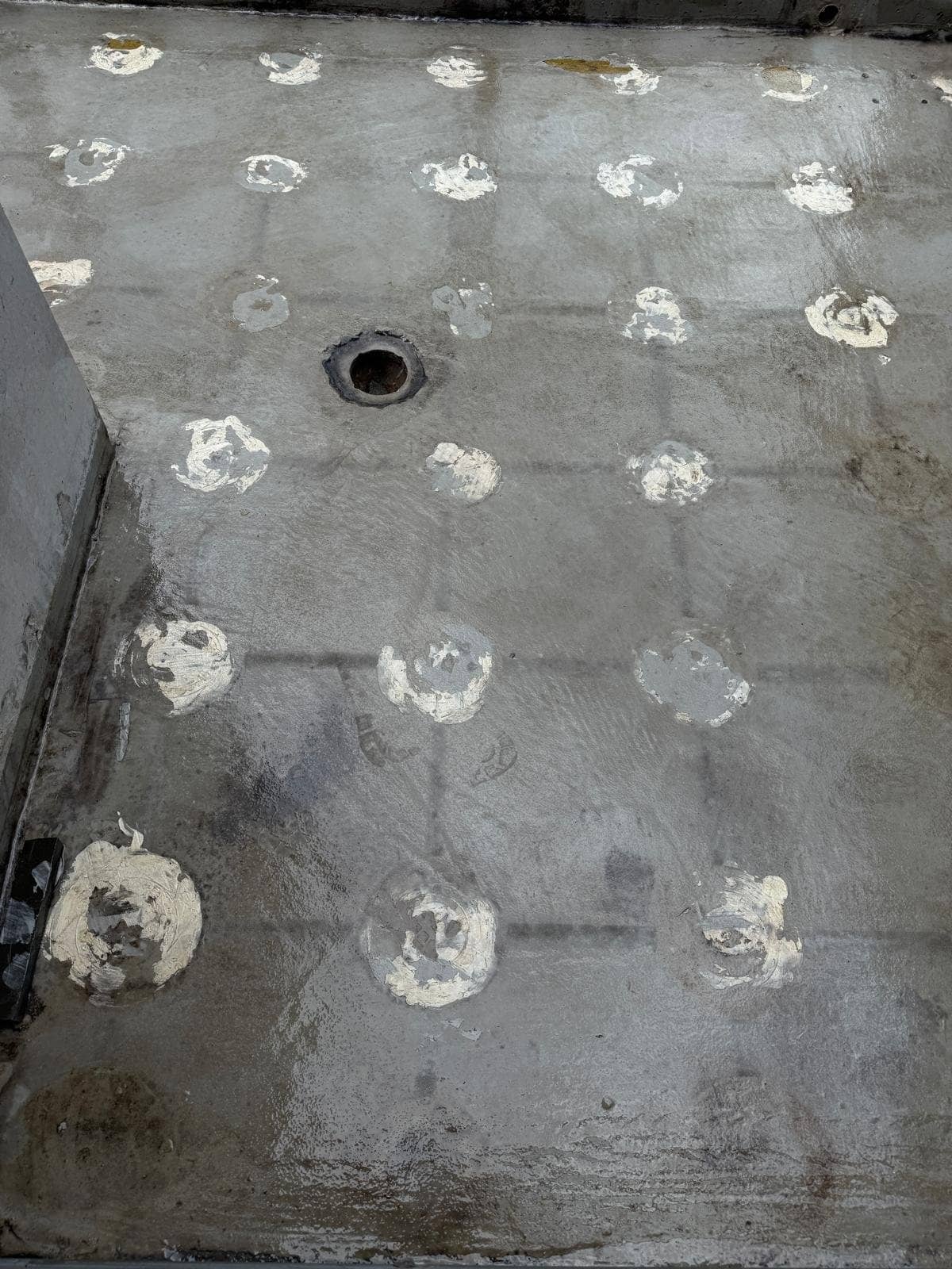 Rooftop waterproofing membrane degraded in a grid pattern where UV reached it through the gaps between pedestal pavers