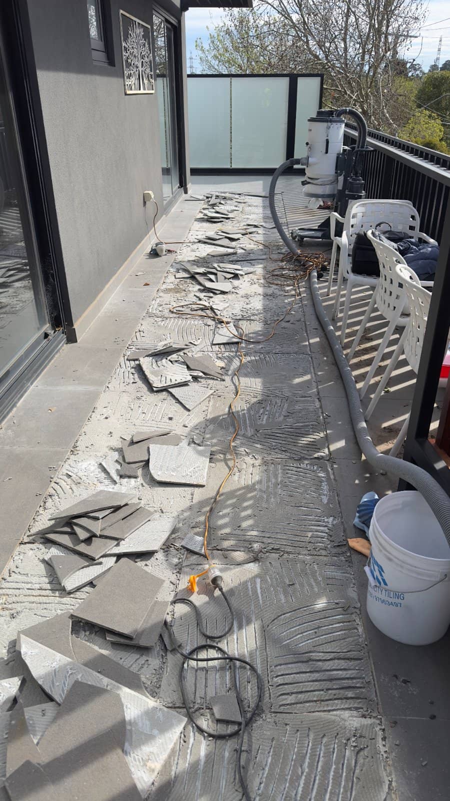 Section of balcony tiles lifted to repair the waterproofing underneath while the sound tiles remain in place
