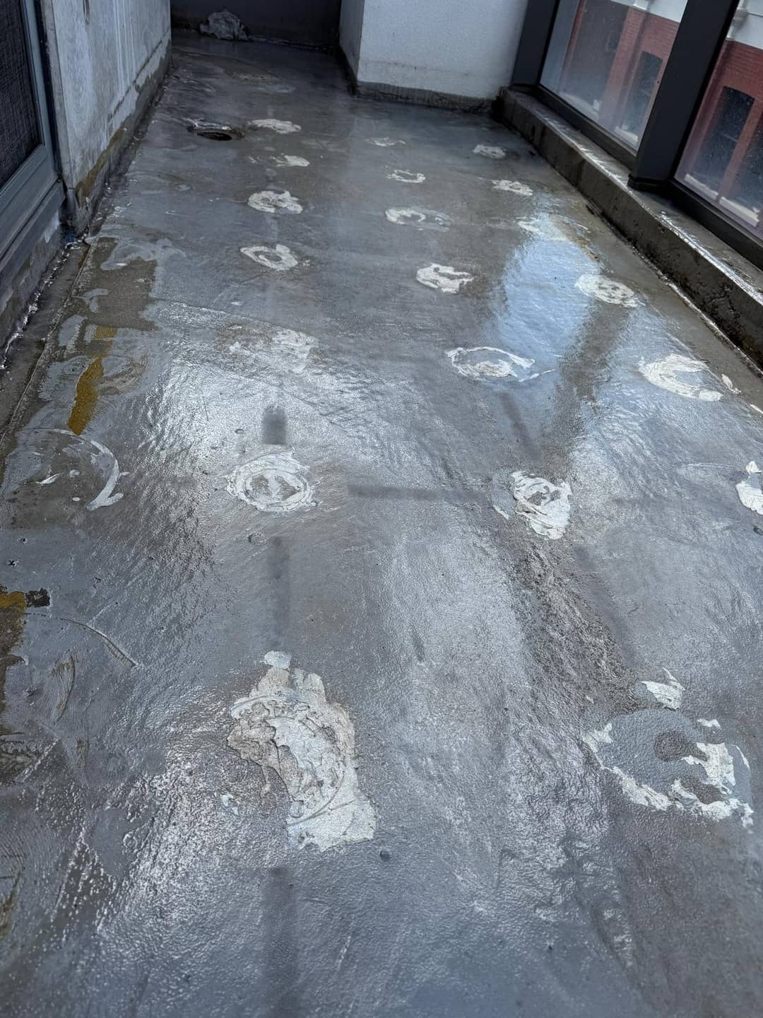 Rooftop waterproofing membrane degraded in a grid pattern where UV light reached it through the gaps between pedestal pavers