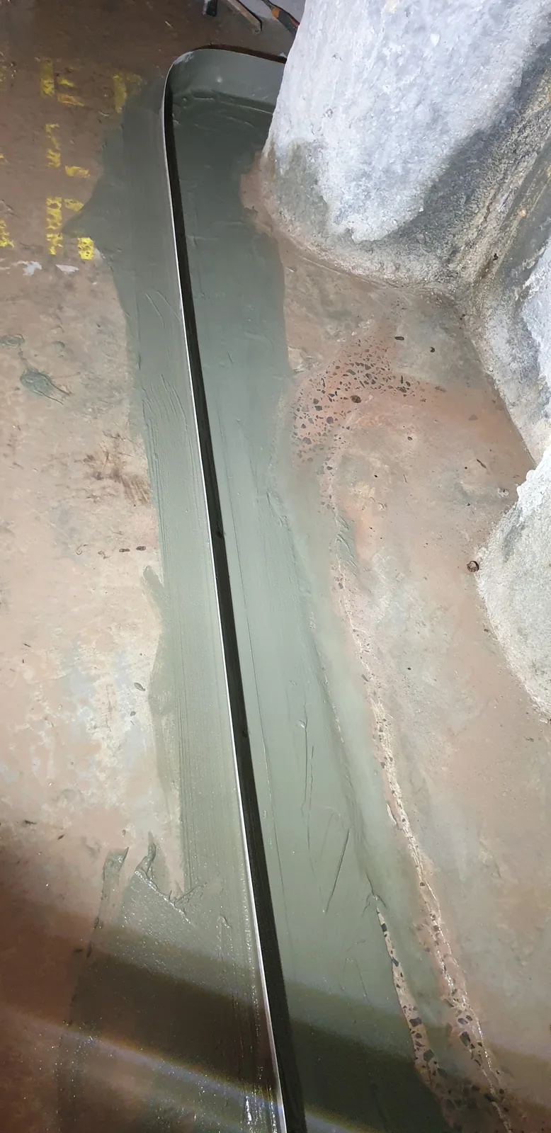 The installed drainage channel at the base of the column