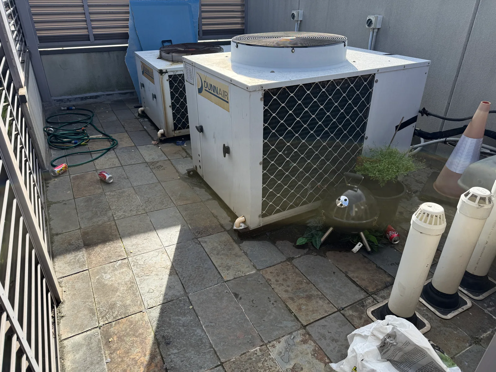 The tiled roof terrace before work, with the two air conditioning units in place