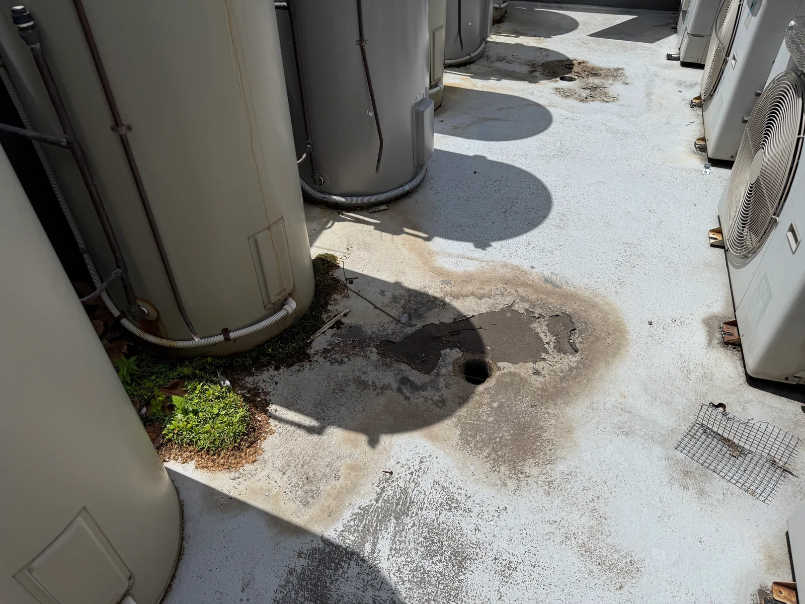 Hot water systems standing directly on the roof with water ponding around their bases