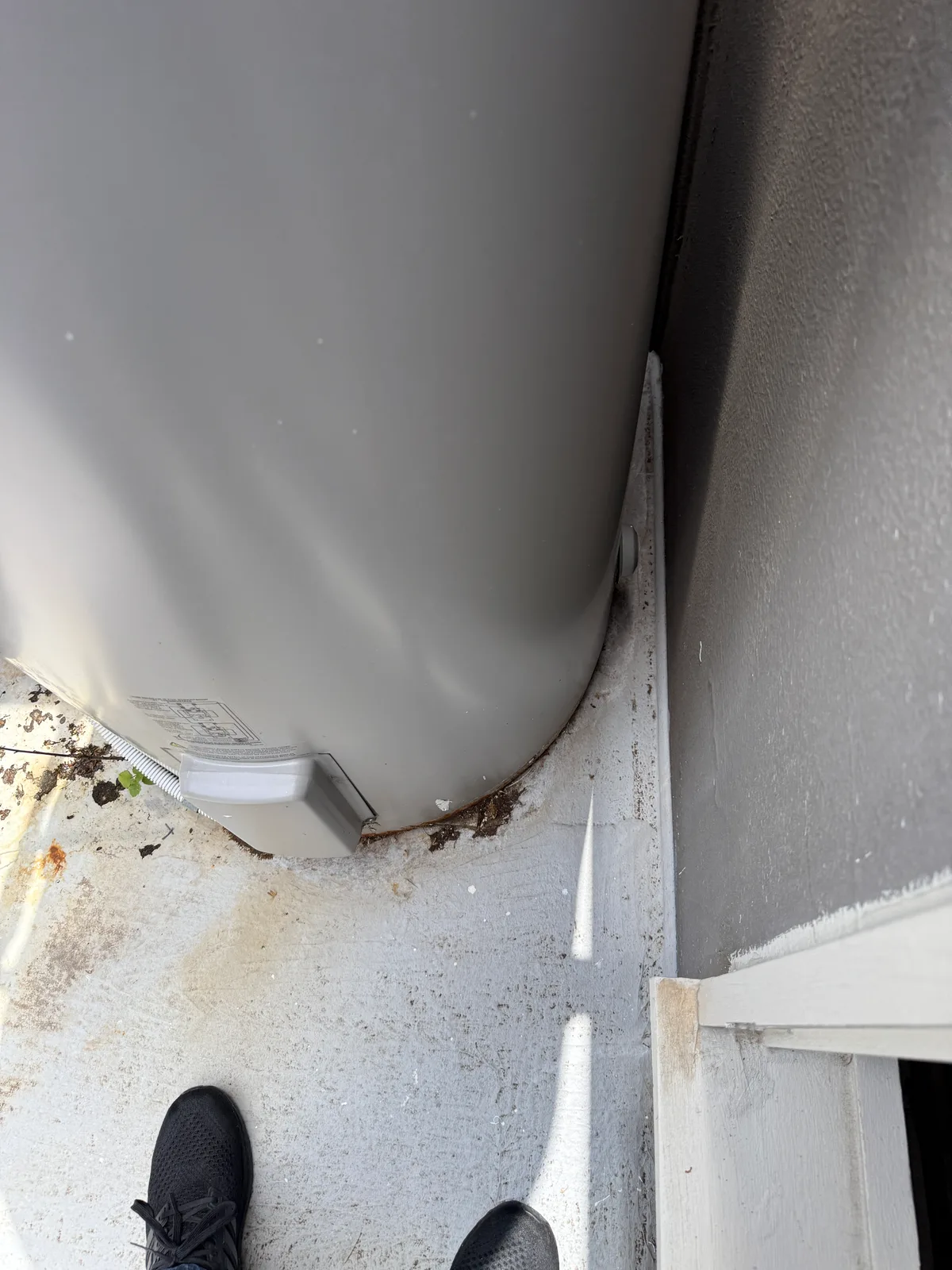 A hot water unit sitting on the roof with no tray beneath it