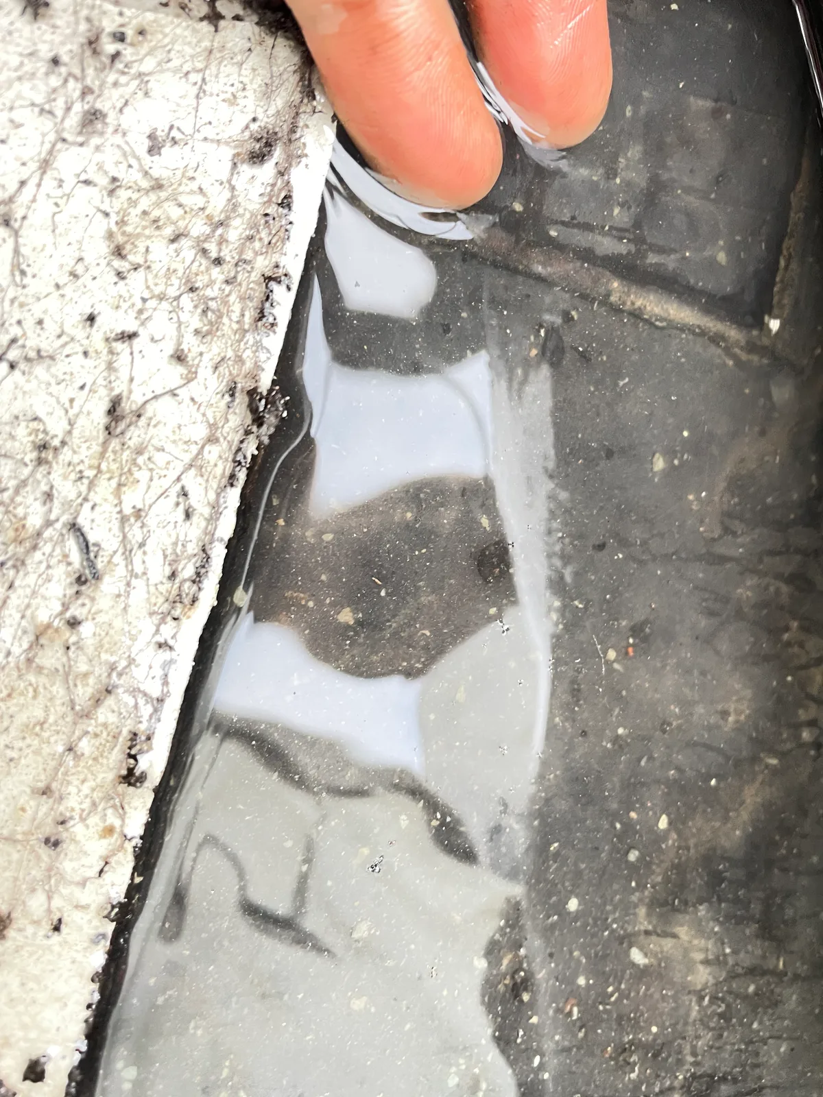 Membrane lifted by hand with water trapped underneath it